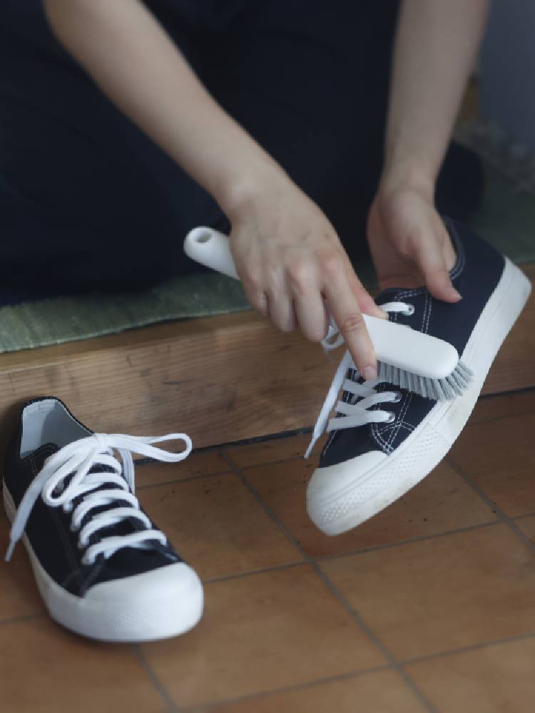 マーナのシューズブラシ。白いポリプロピレン柄と耐久性のあるポリブチレンテレフタレート製の毛を備え、靴をきれいに洗うためのブラシ。サイズは約36×226×41mm、軽量な約64g。