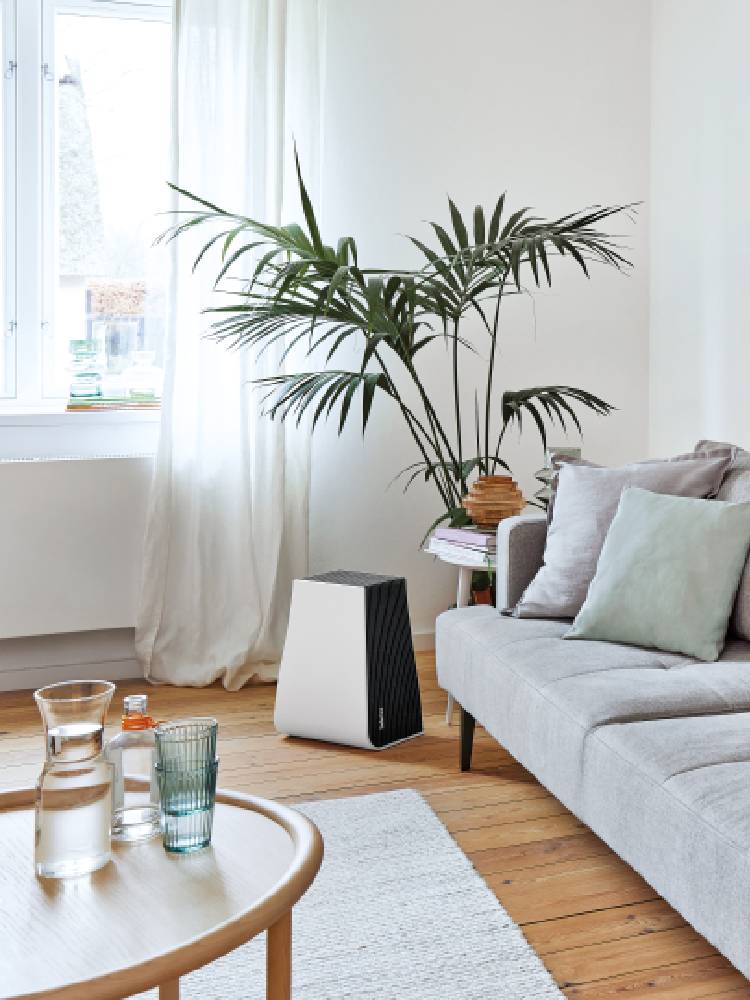 スタドラフォーム ジョージ エアウォッシャー加湿機能付き空気清浄機と付属のウォーターキューブが木製フロア上に置かれている様子