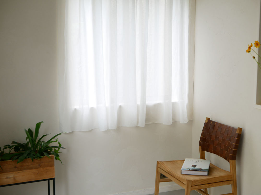 「natsusobiku」リネンのクリップ留めレースカーテン1枚がリビングルームの窓に設置され、植物とランプが調和したインテリア