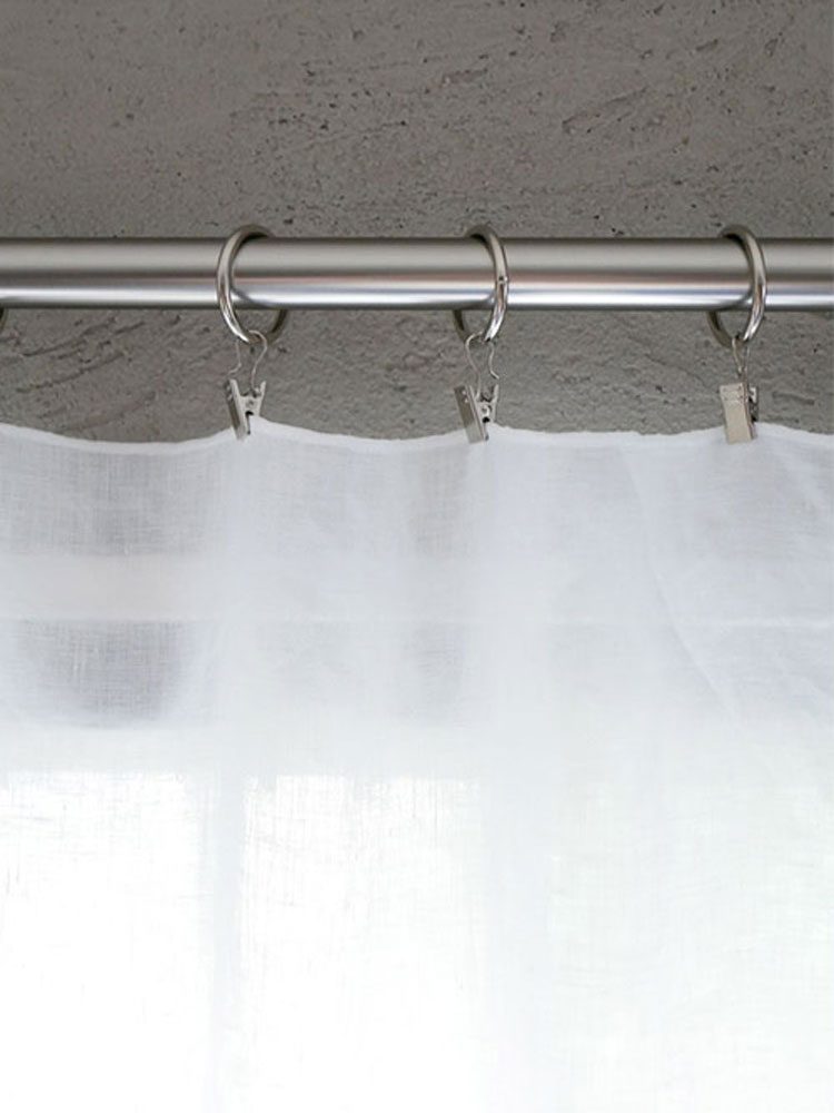 灰色の麻100%素材で作られたクリップ留めレースカーテンが窓に掛かっている様子