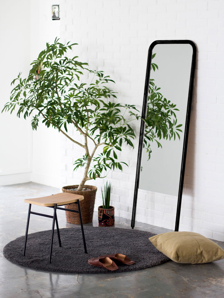 木製フローリングのリビングルームに設置されたNOWHERE LIKE HOMEのスタンドミラーとラダーハンガー、周囲に観葉植物が配置されている様子