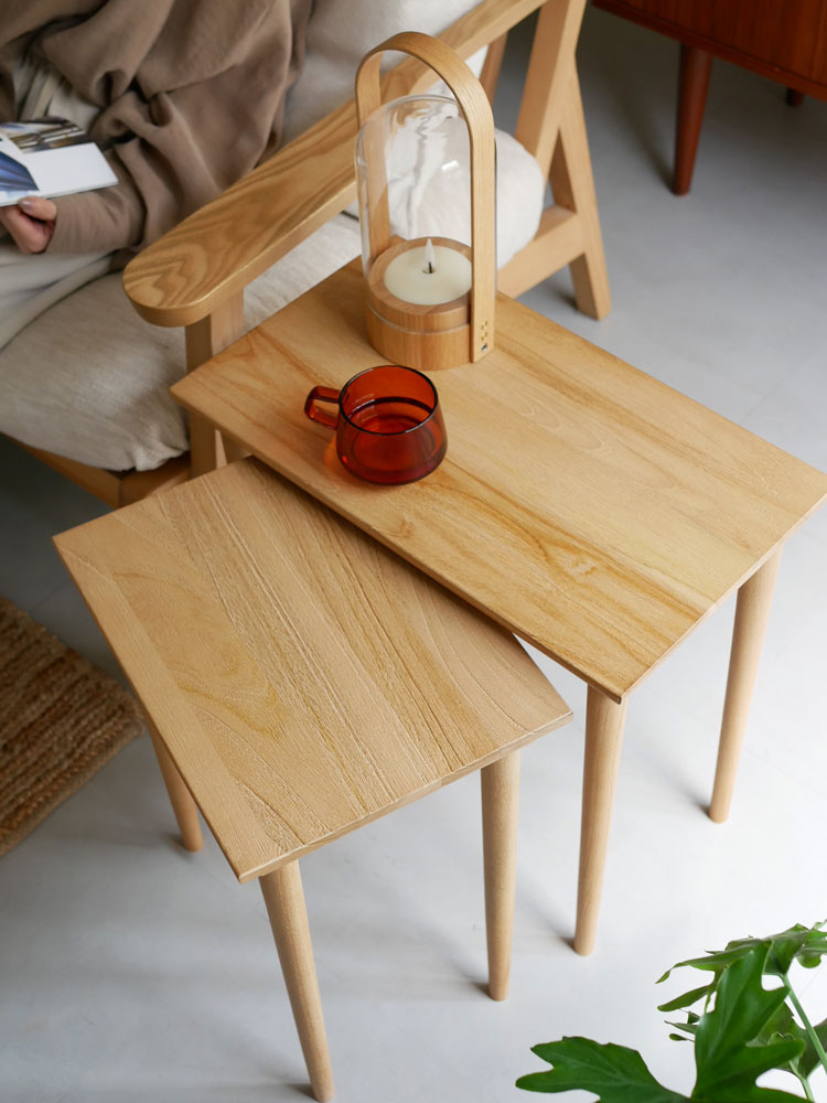 チーク製ネストテーブルに花束と木製小物が飾られています