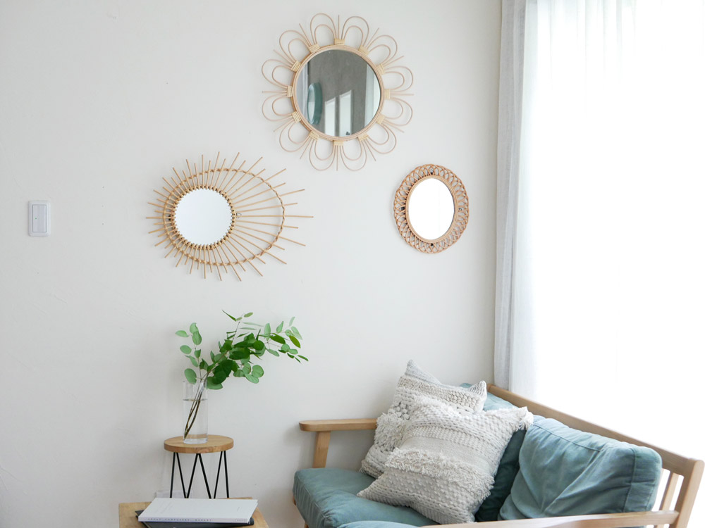 リビングルームに置かれたアデペシュのrottaラタンミラー