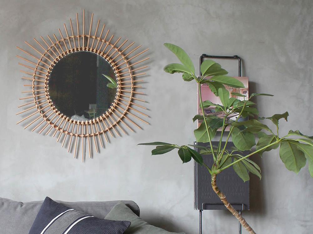 ラタンミラーと花瓶が飾られたリビングルームのインテリア