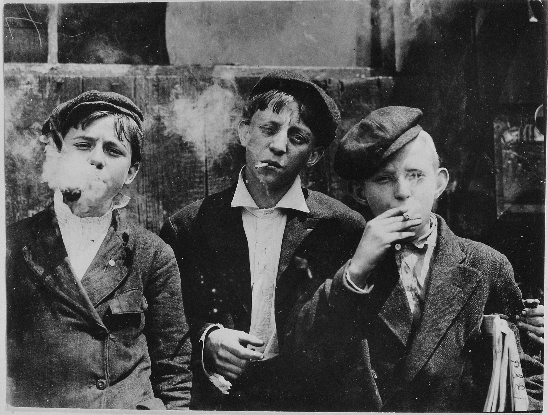 11:00 A.M. Monday, May 9th, 1910. Newsies at Skeeter's Branch, Jefferson near Franklin. They were all smoking. Location: St. Louis, Missouri., 1910 (Internet Archive)