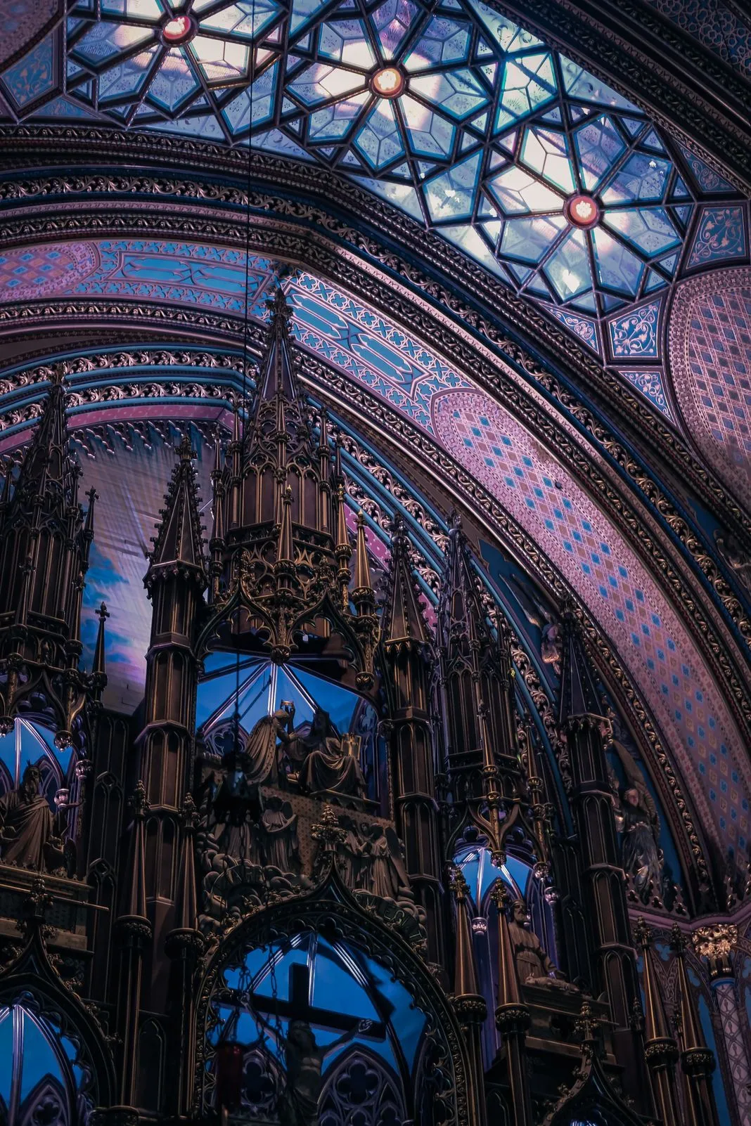 Ornate Gothic altar and painted vaulted ceiling inside a cathedral