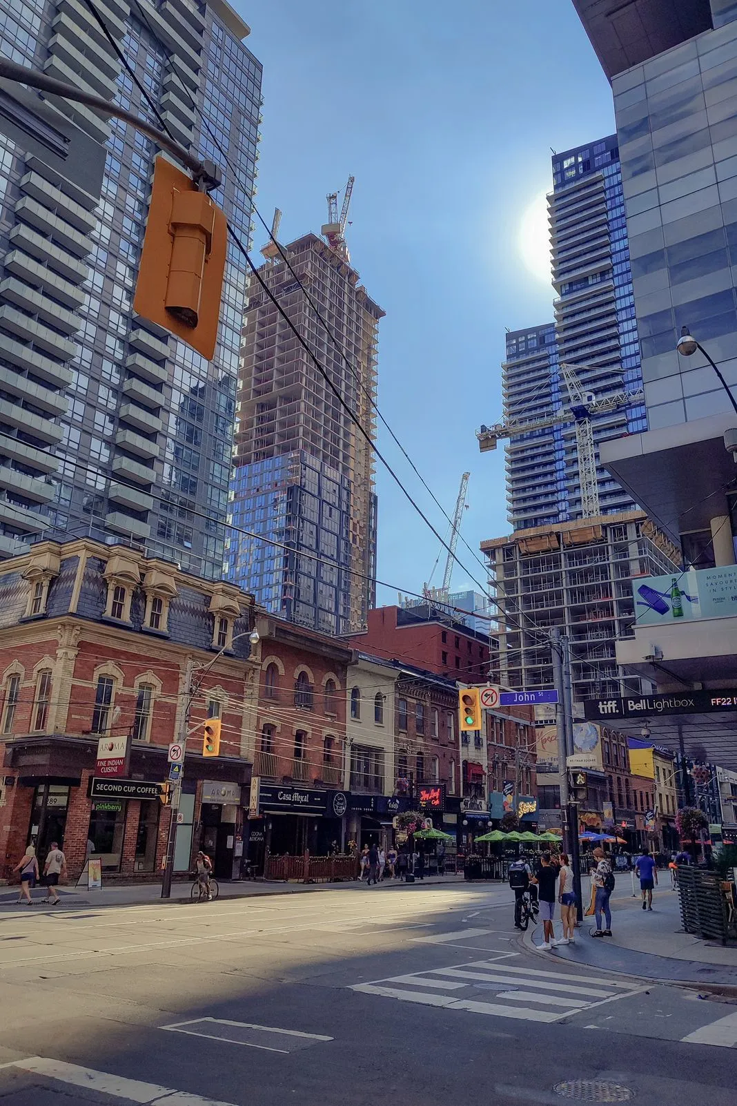 City street corner with skyscrapers under construction and shops below