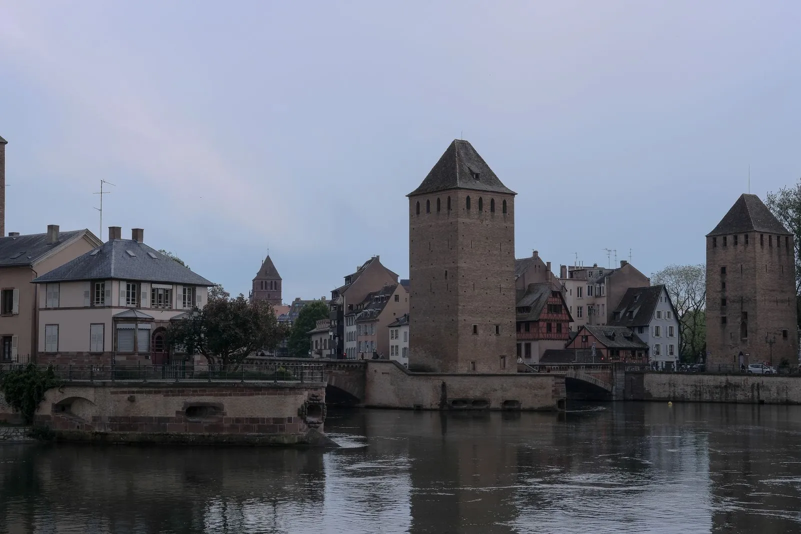 Medieval covered-bridge towers reflected in the river at dusk
