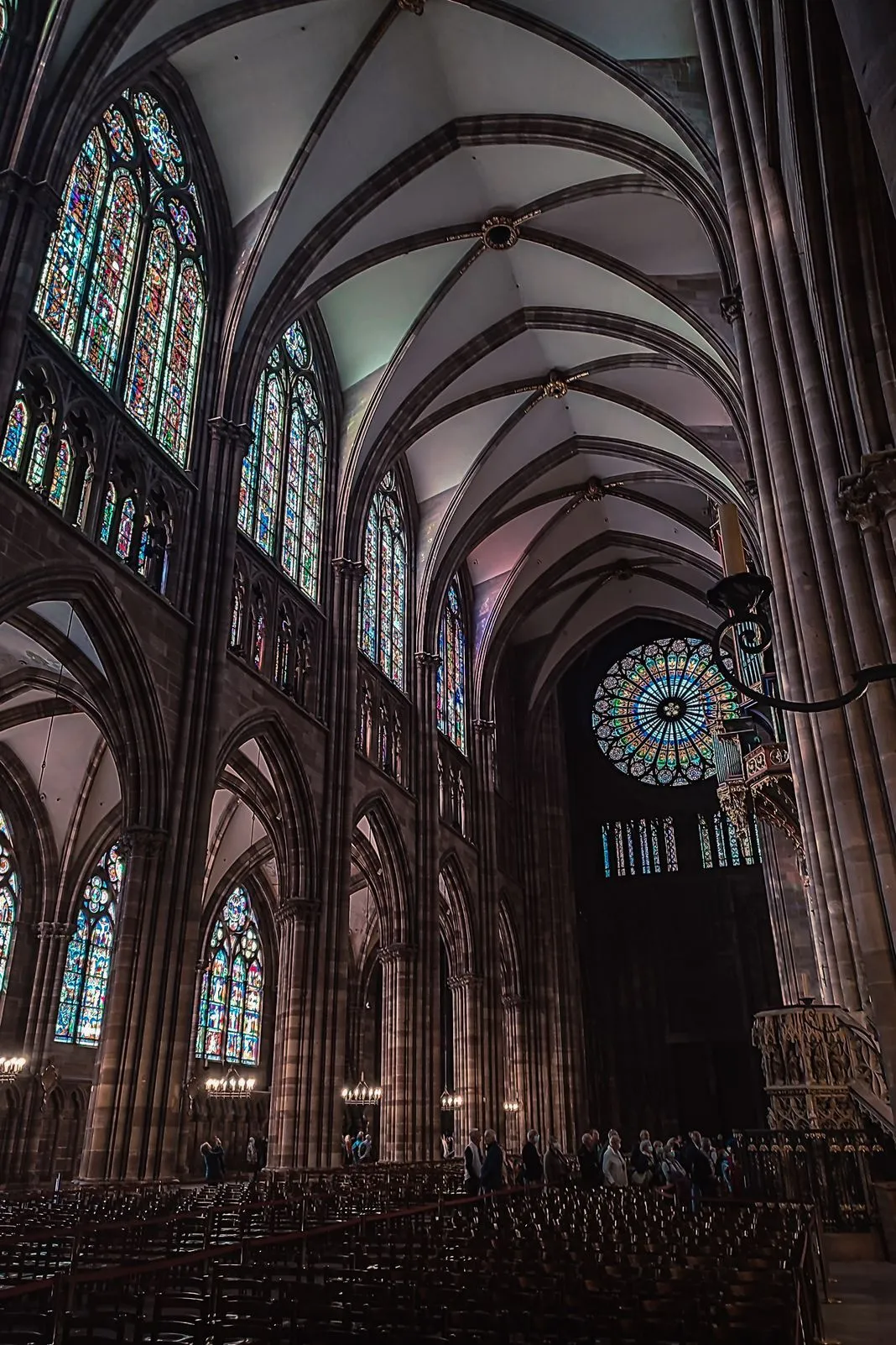 Gothic cathedral interior with a soaring vaulted ceiling and stained-glass windows