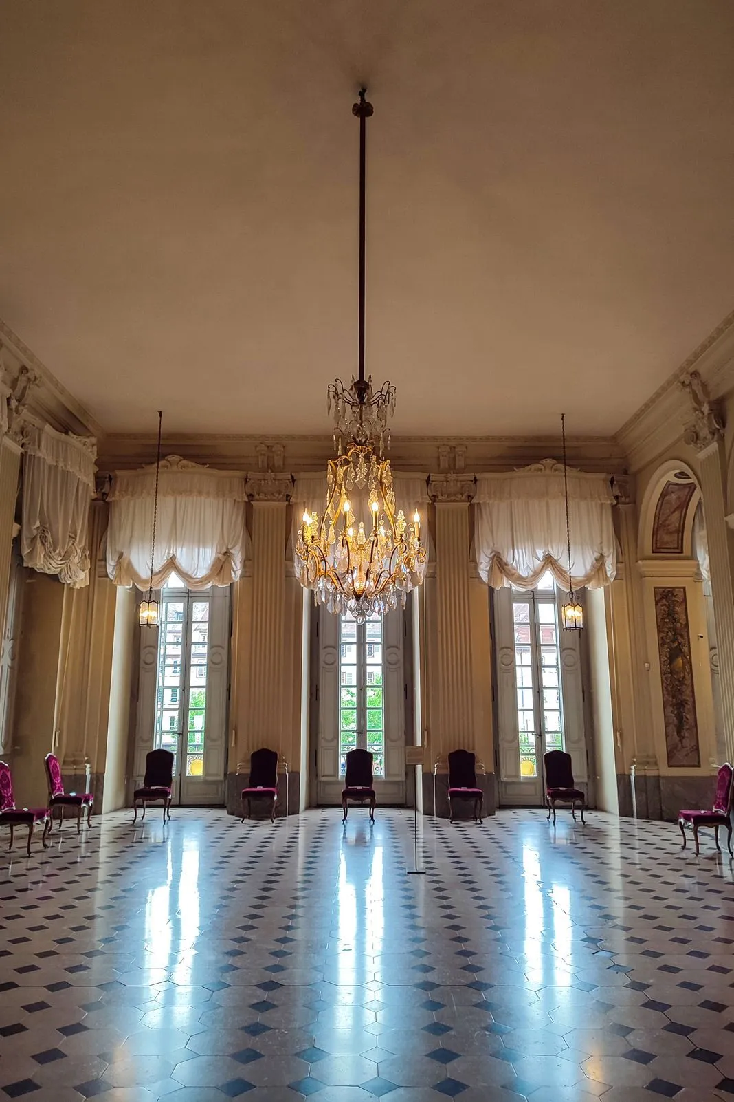 Elegant ballroom with a crystal chandelier and black-and-white checkered floor