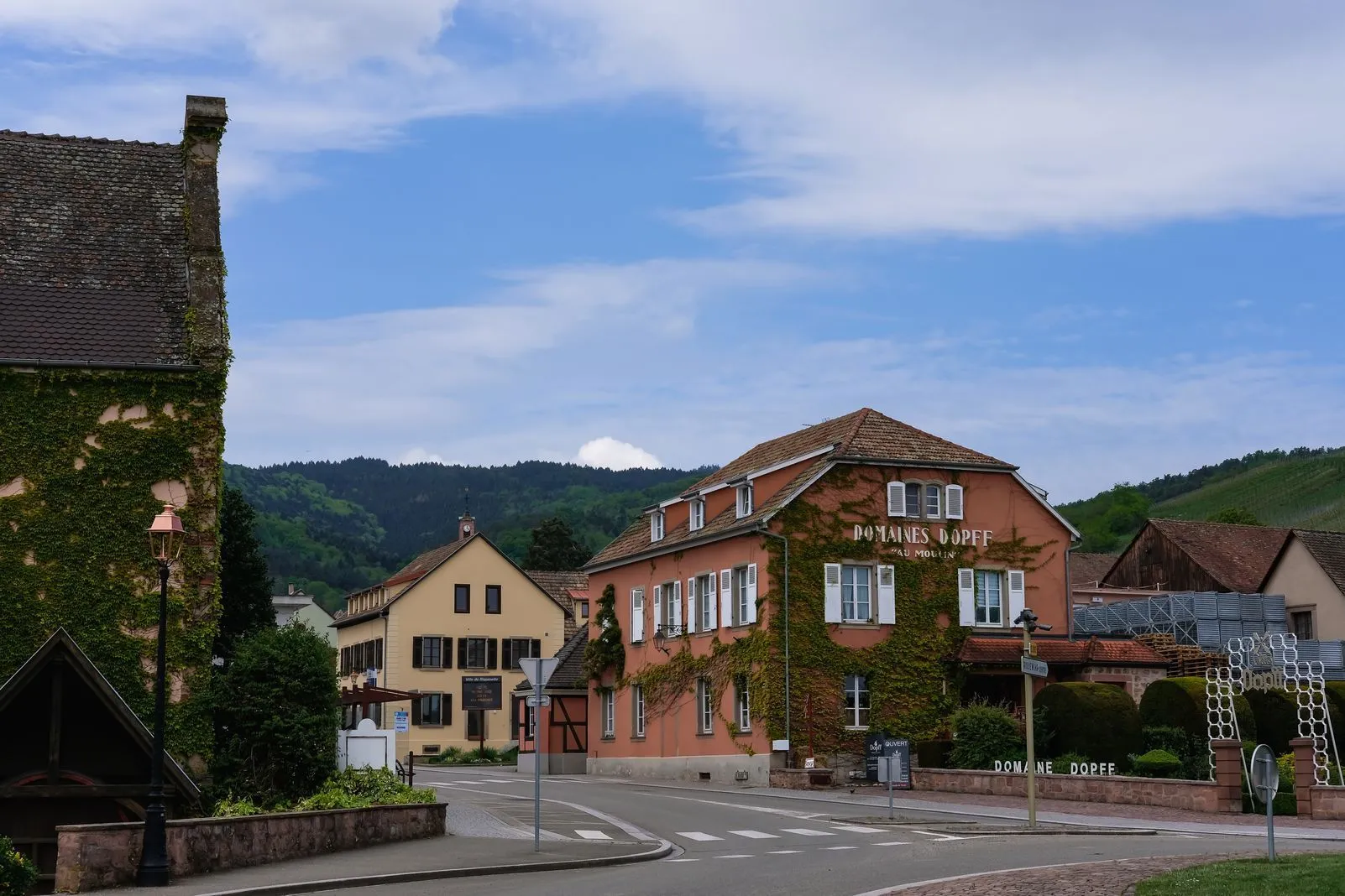 An ivy-covered building beside the pink-walled Domaines Dopff winery