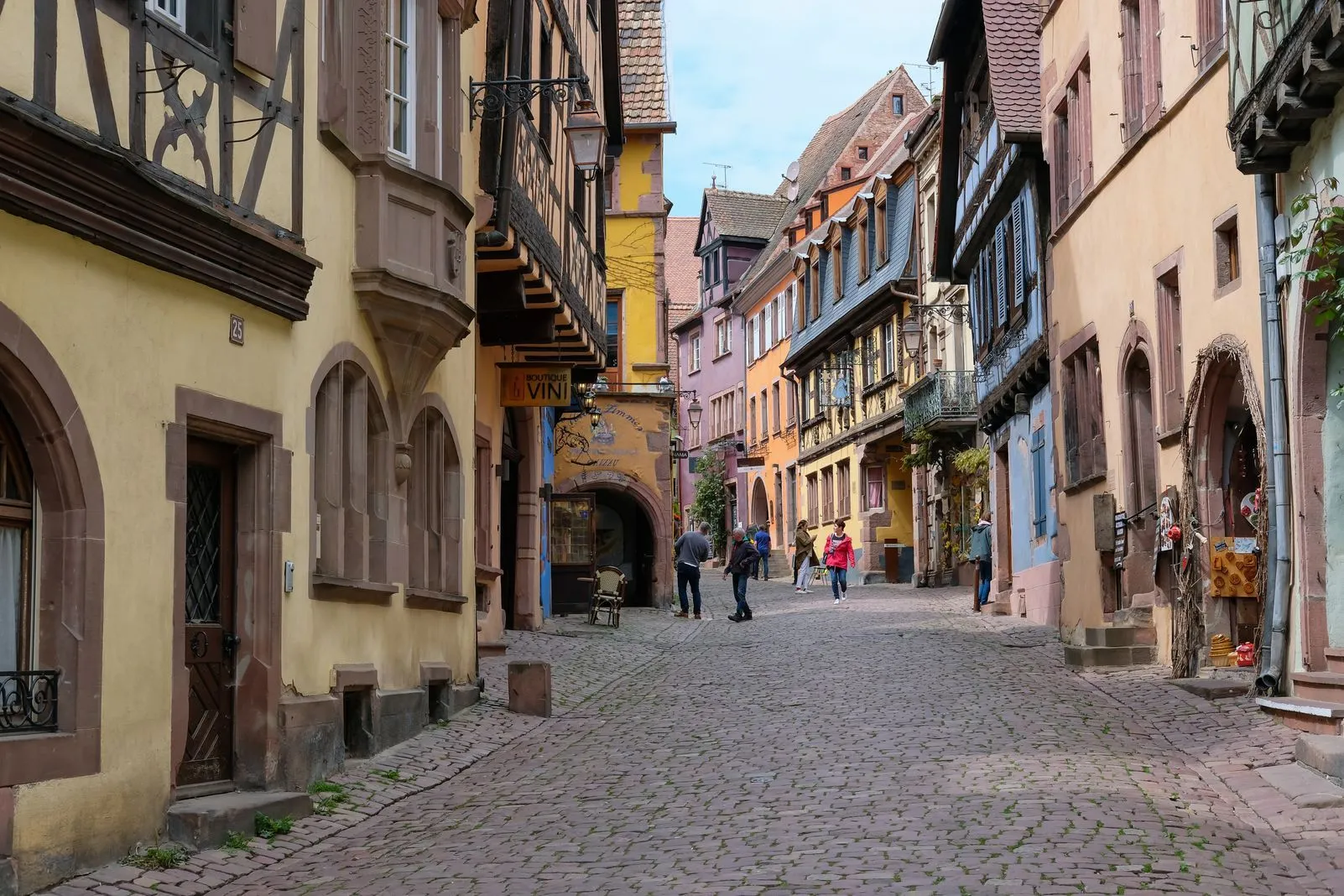 A cobblestone street lined with pastel half-timbered shops in the old town