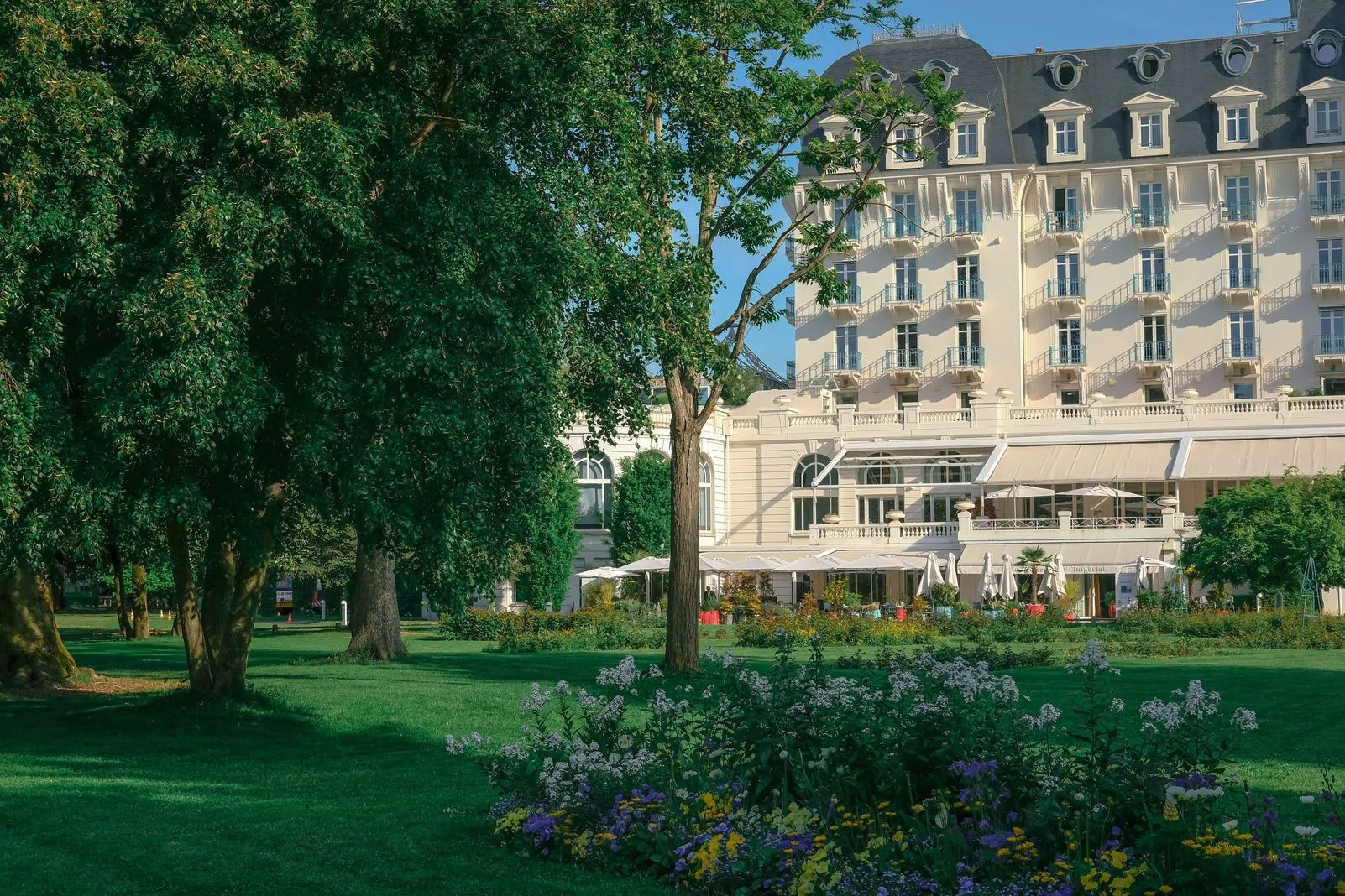 Grand hotel with turreted rooftop overlooking manicured lawns and flowerbeds