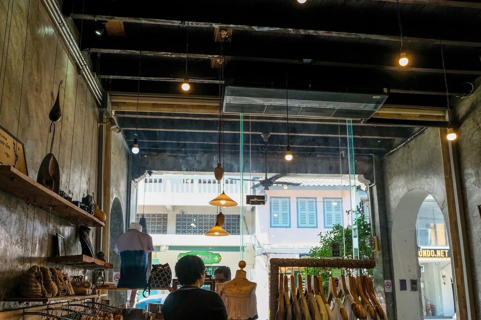 Interior of a boutique shop with hanging pendant lights and clothing racks
