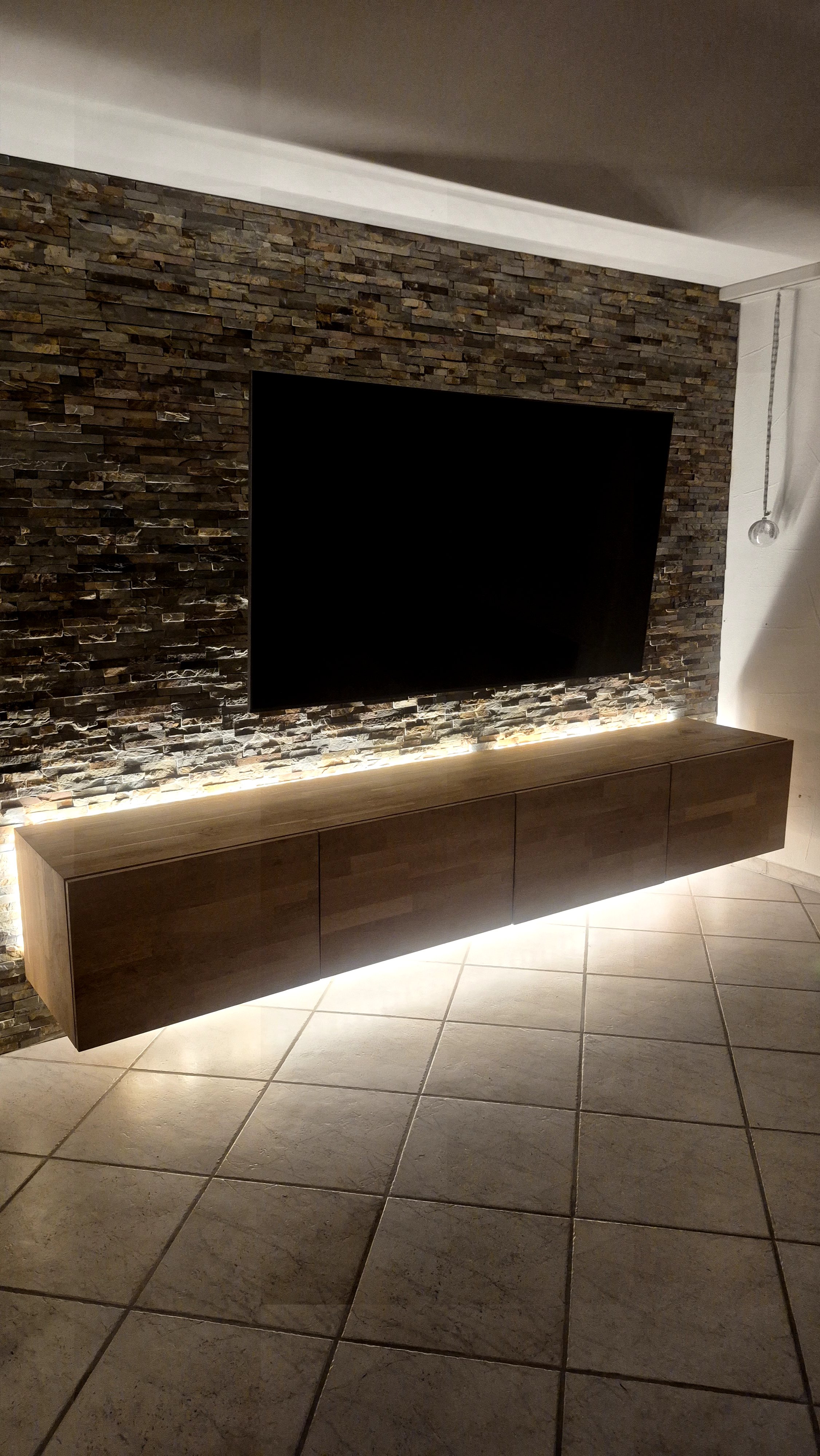 Schwebendes Sideboard und Natursteinwand