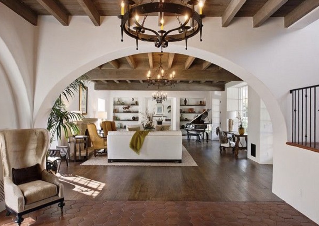 A spanish style room with terracotta tiles and arched doorways