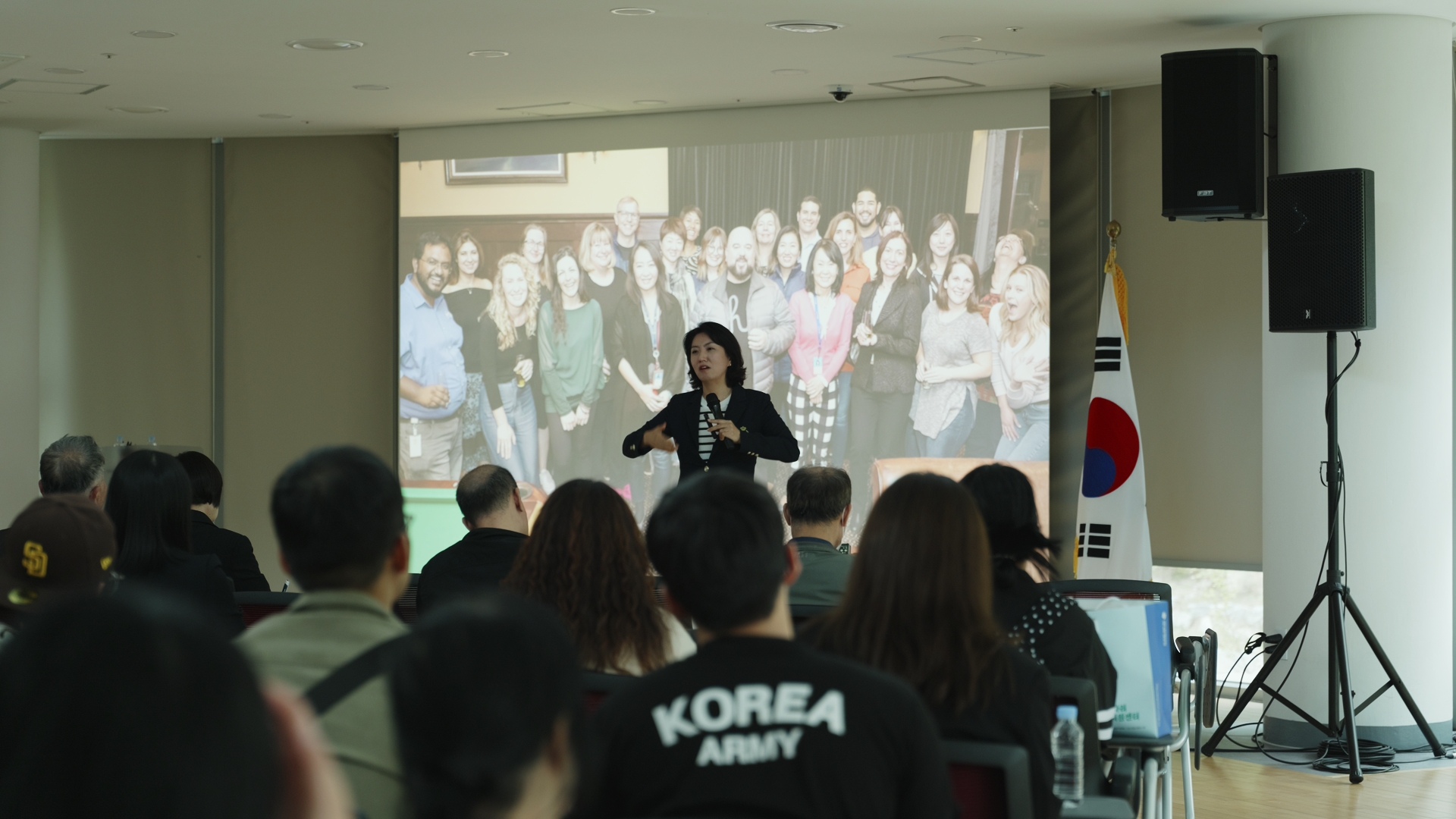 2025 의정부시 일자리박람회 실내 강연 순서 장면. 발표자 뒤 스크린과 좌우 스피커 배치가 보인다. 송년회·시무식의 대표 인사나 신년사 순서도 같은 방식으로 화면과 음향을 미리 맞춰 둔다.