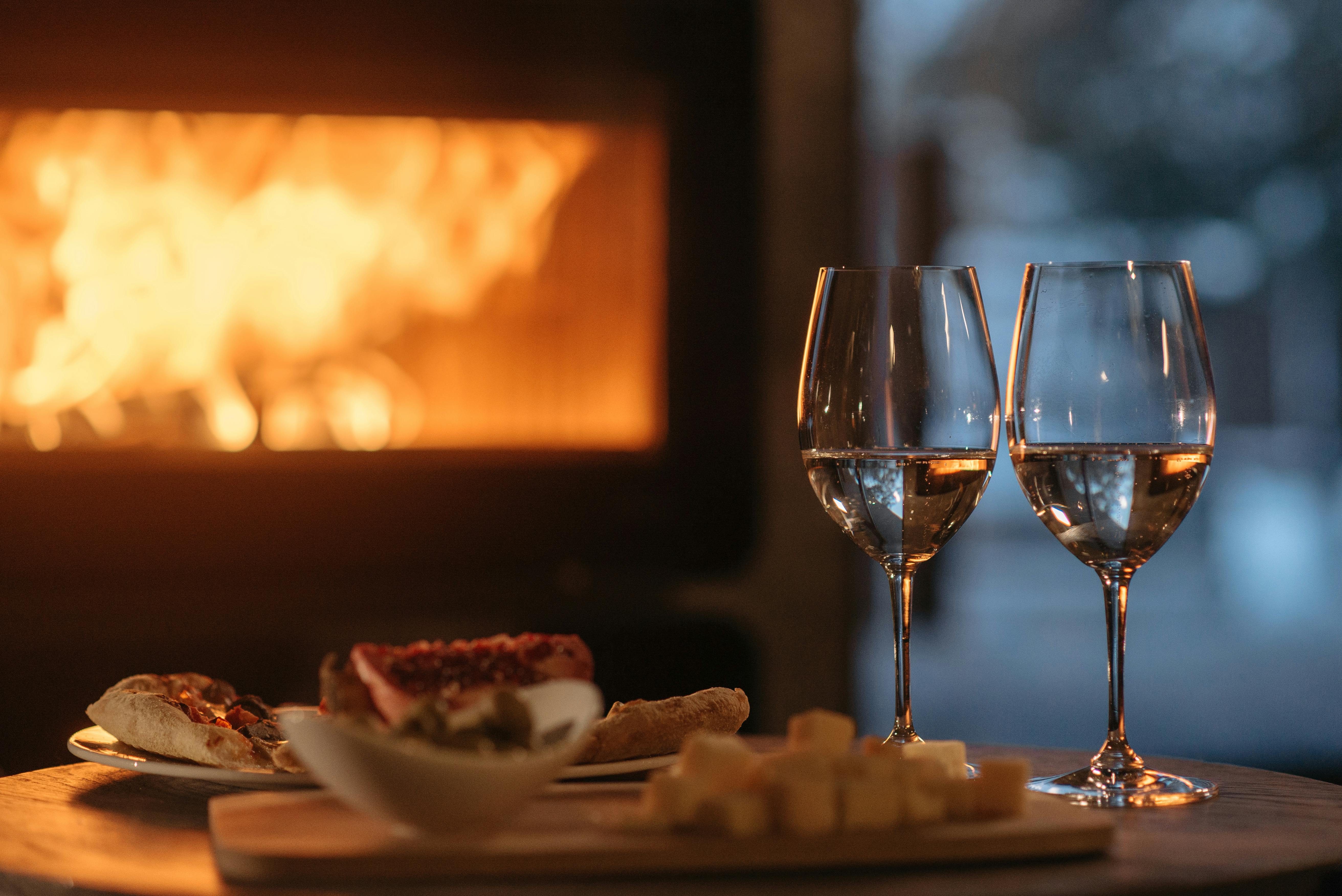 clear-wine-glass-beside-white-ceramic-plate-with-food