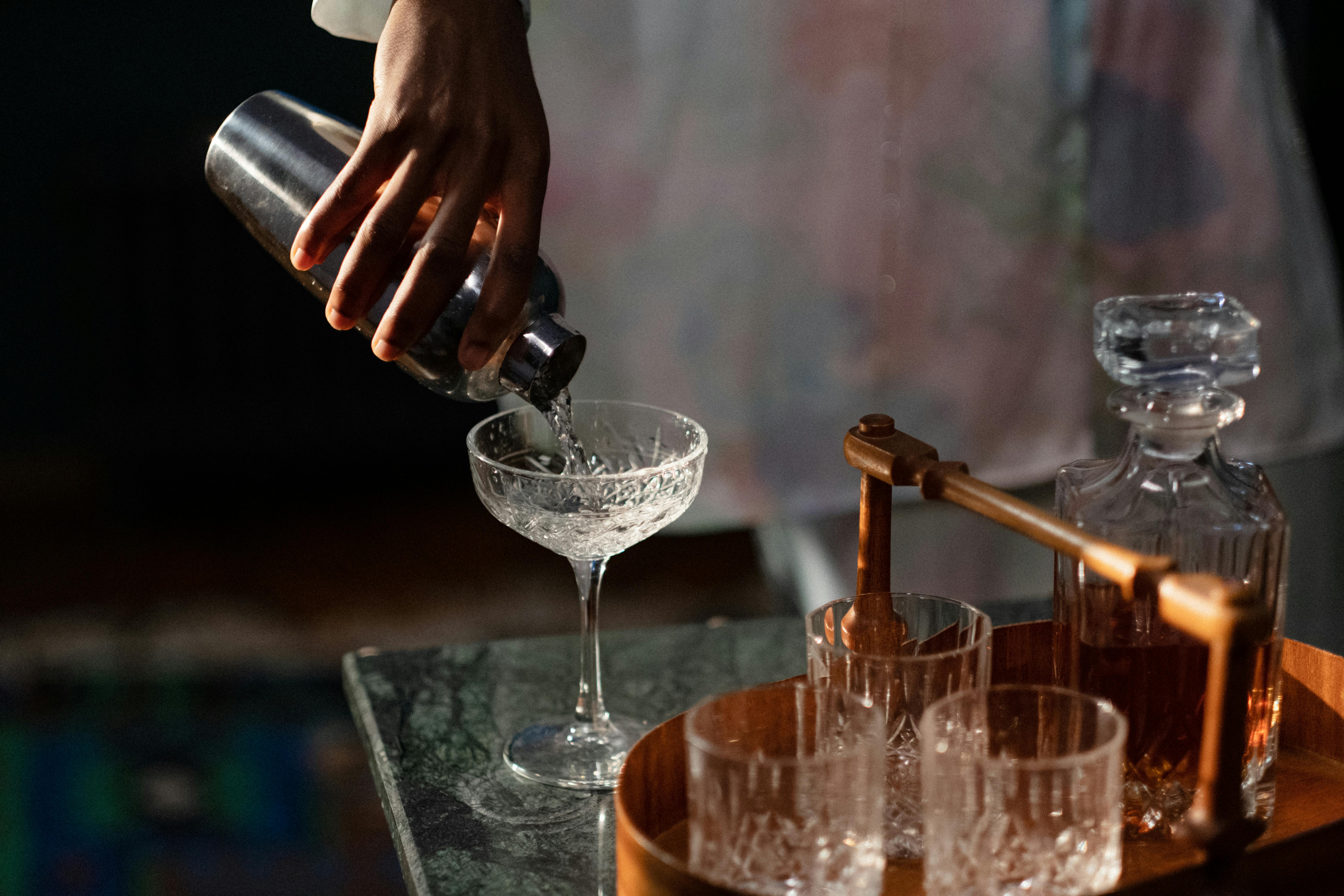 hand-pouring-cocktail-into-glass-from-shaker