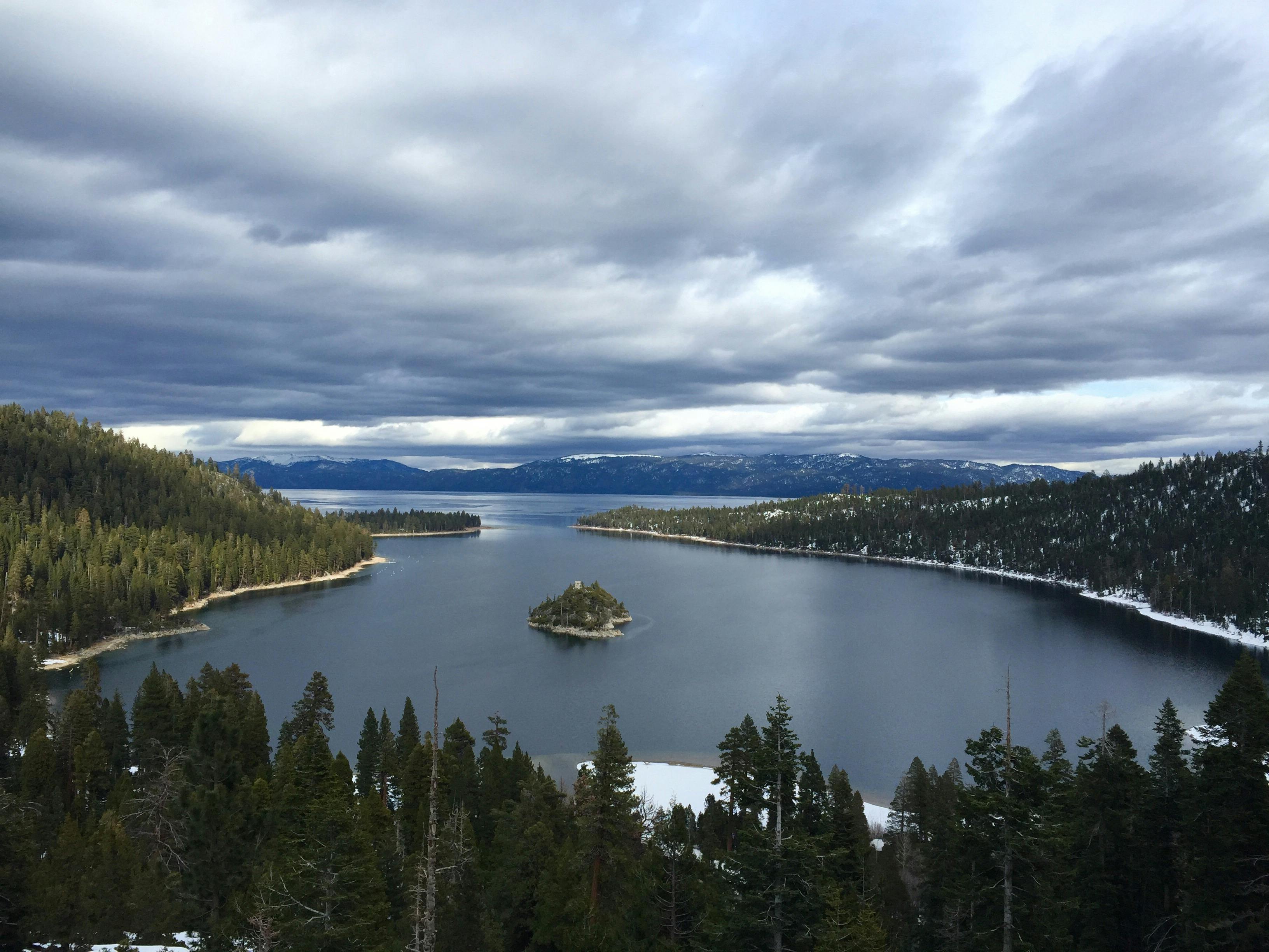 person-showing-lake-under-the-white-clouds