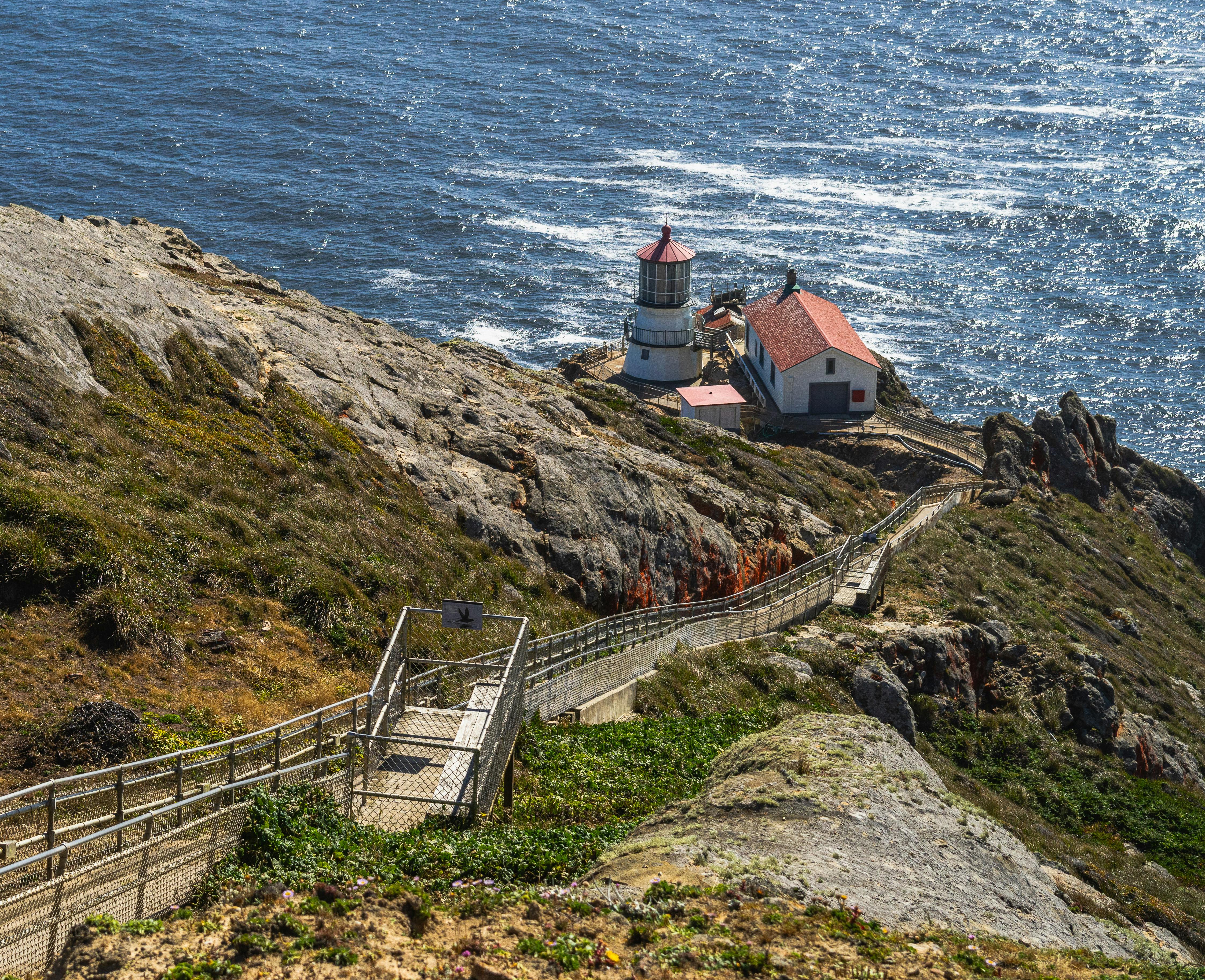 a-lighthouse-is-on-a-cliff-overlooking-the-ocean