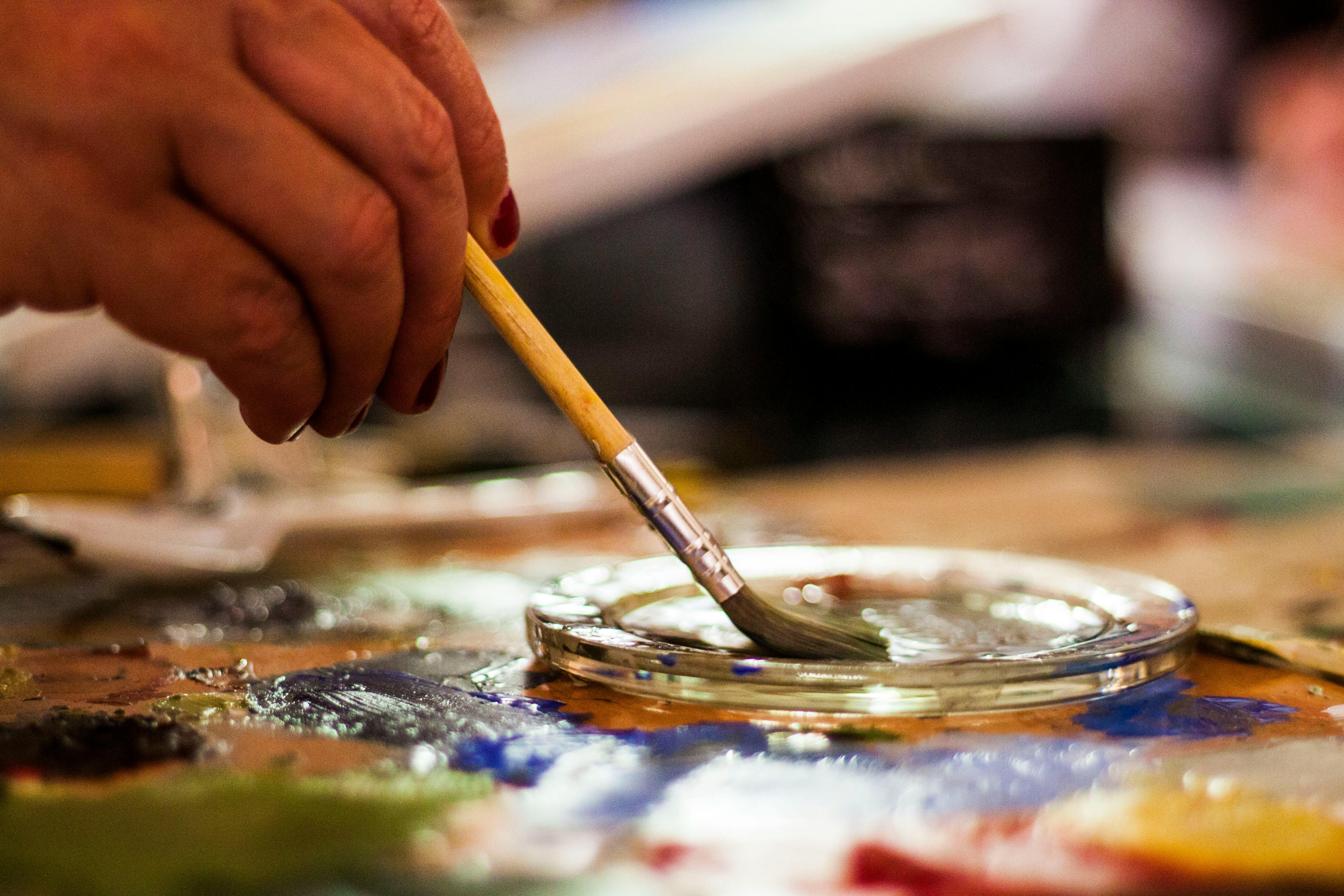 person-holding-brown-and-gray-paint-brush