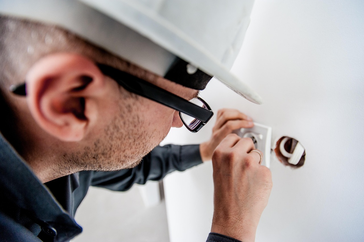Ein professioneller Handwerker arbeitet an einem Verteilerkasten mit Messgeräten