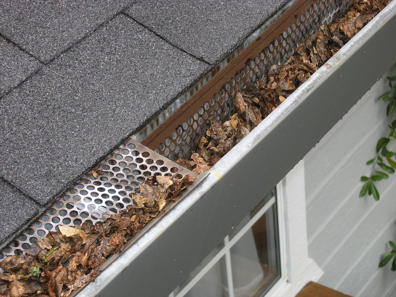 Close-up view of clean aluminum gutters along the roof edge of a house.