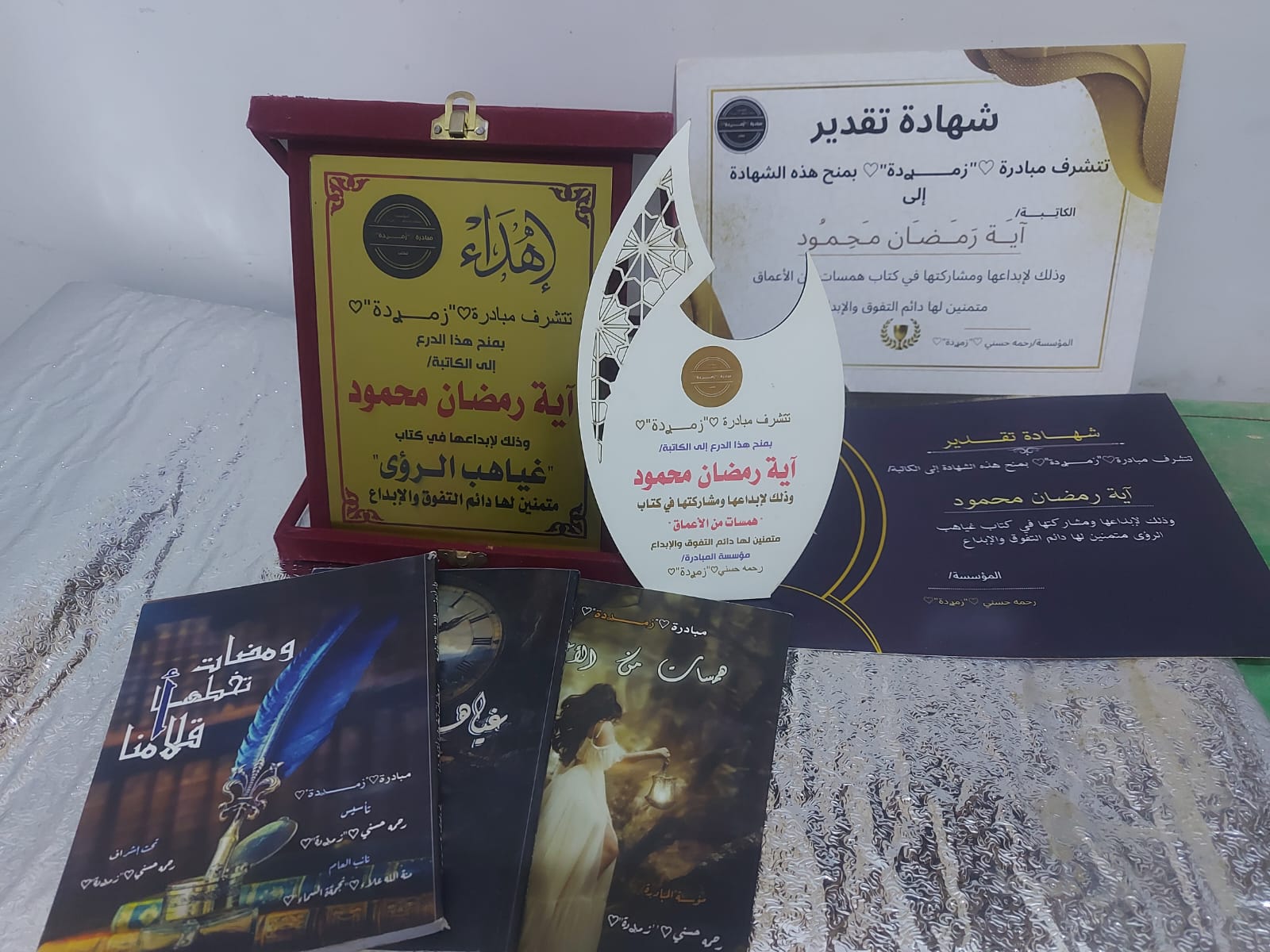 صورة جماعية لجوائز وشهادات اية رمضان مع كتب مبادرة زميدة