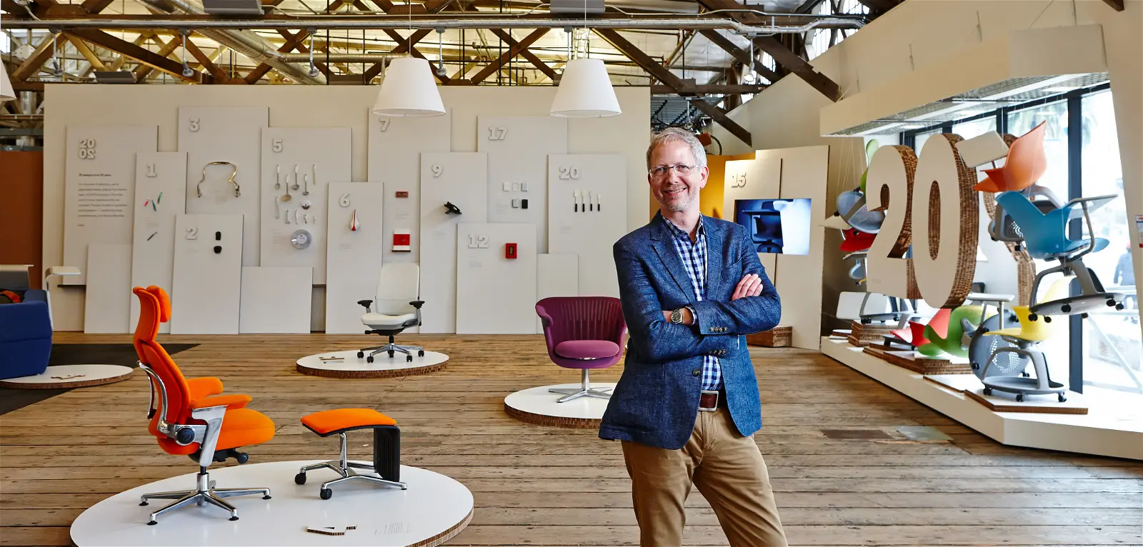 Thomas standing in front of his work at his 20th work anniversary
