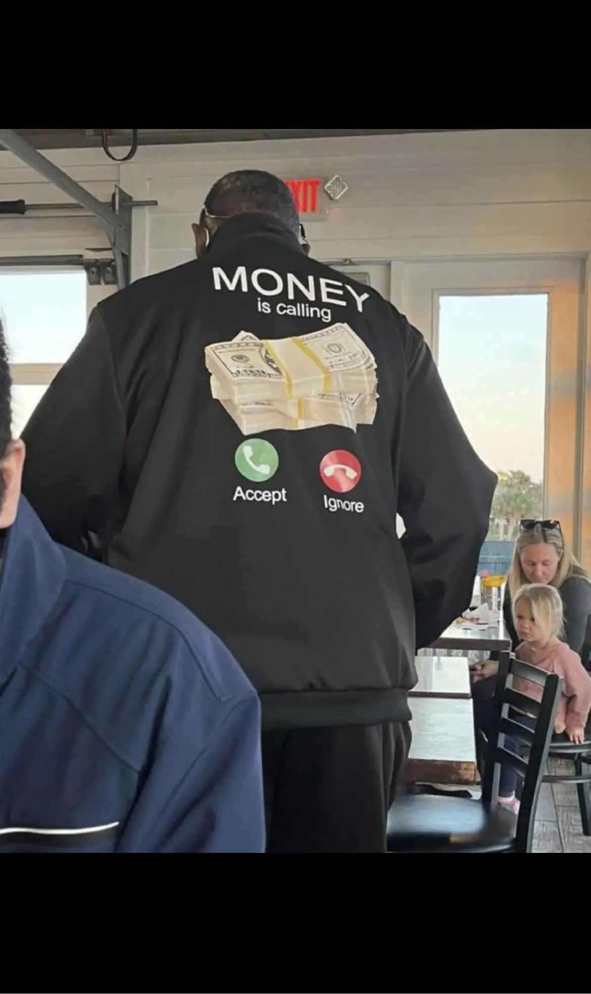 Man with jacket with iphone call screen meme that says "Money is calling... Accept/ignore"