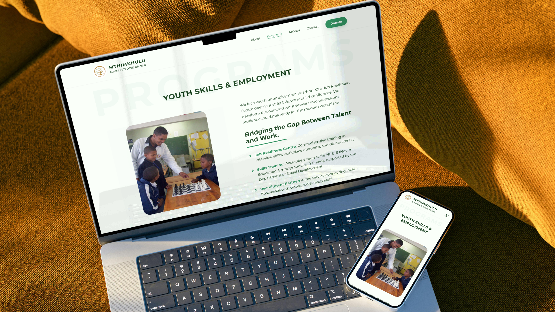 Desktop and smartphone screens showcasing the Mthimkhulu Youth Skills and Employment program details page featuring a youth chess activity photo.