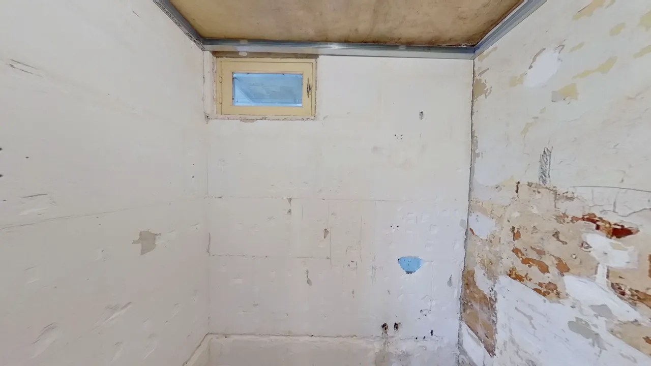 Salle de douche en travaux, entièrement dénudée.