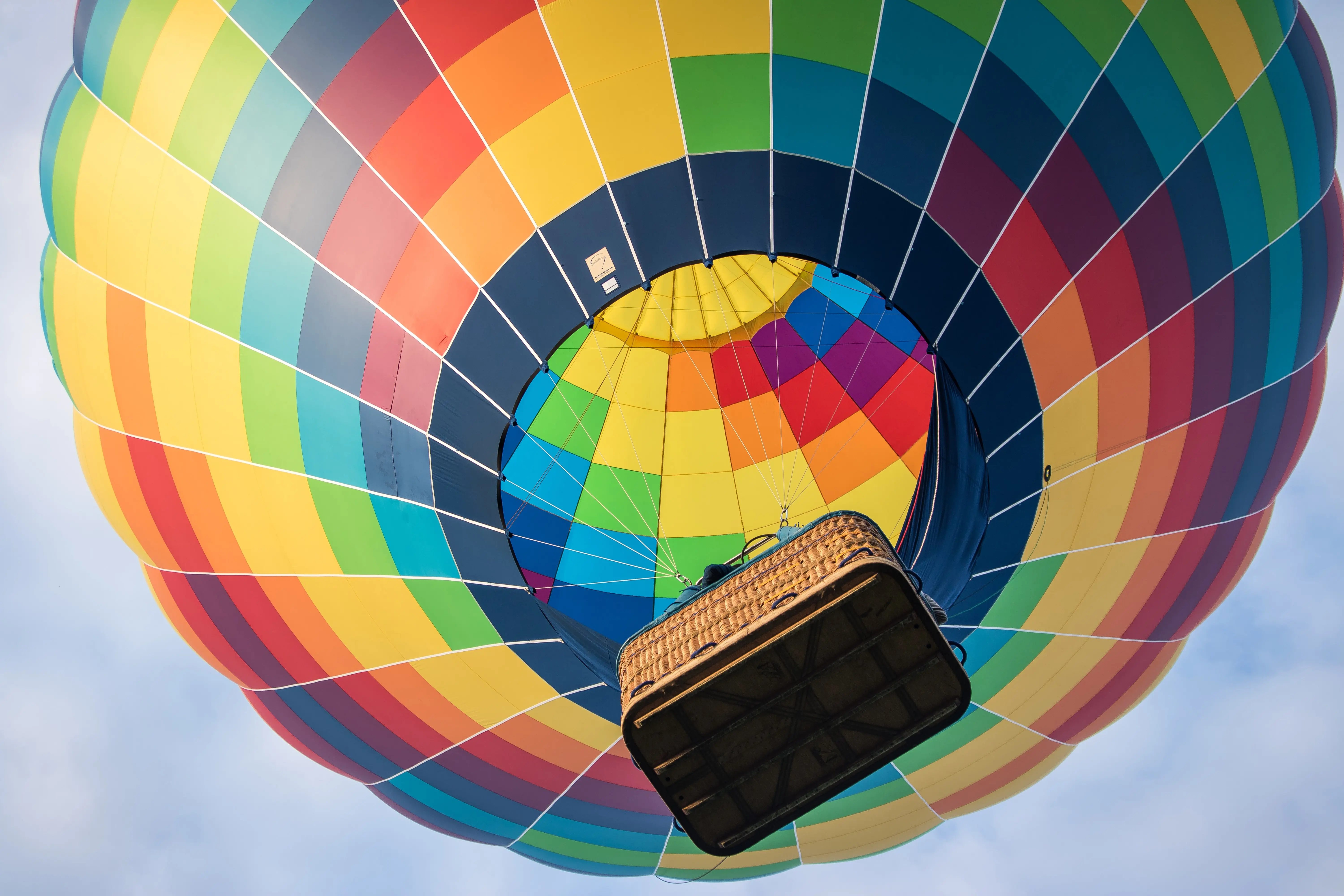 Under view of a very colorful air balloon taking off