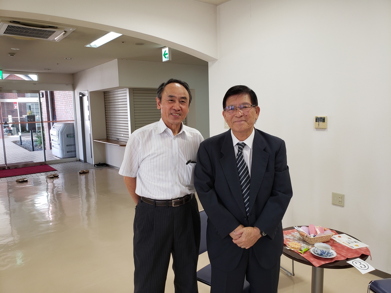 施設入口で並んで立つ男性スタッフ2名