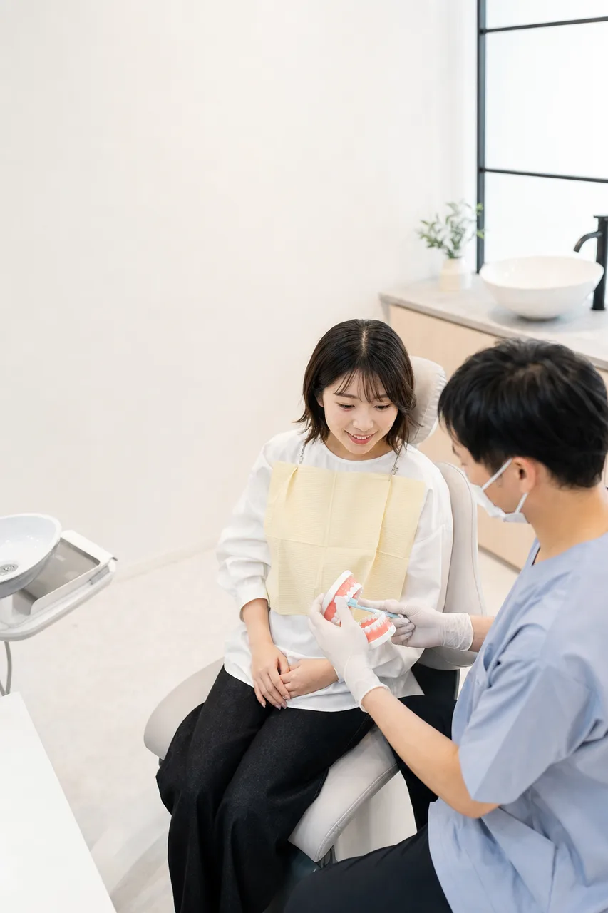 歯科医院で口腔ケアの説明を受ける患者（Webサイト用）。歯科医院で口腔ケアの説明を受ける患者をテーマに、Webサイト用として使いやすく構成した商用AI素材です。