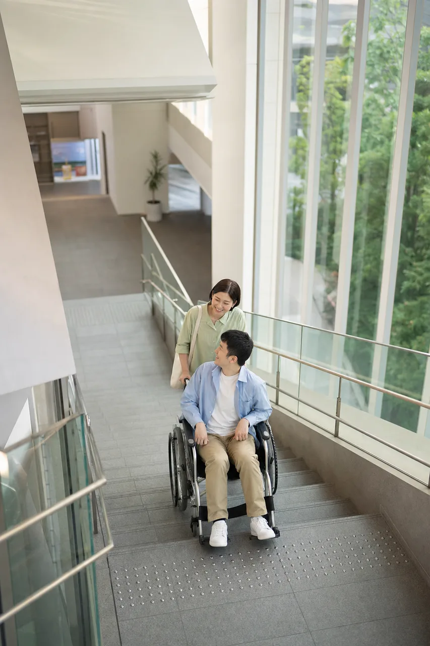車椅子でバリアフリー施設を利用する人（SNS広告用）。車椅子でバリアフリー施設を利用する人をテーマに、SNS広告用として使いやすく構成した商用AI素材です。