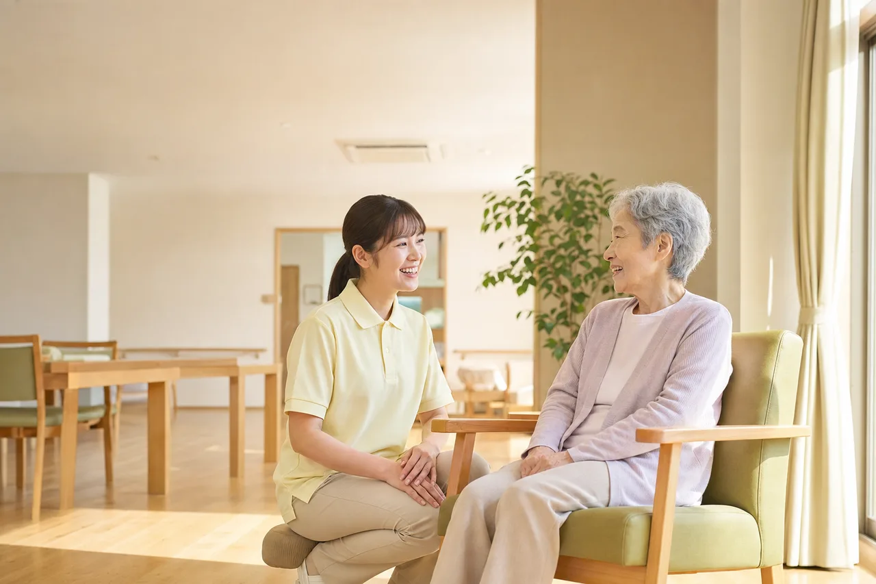 介護施設で会話する介護士と高齢者（採用ページ用）。介護施設で会話する介護士と高齢者をテーマに、採用ページ用として使いやすく構成した商用AI素材です。