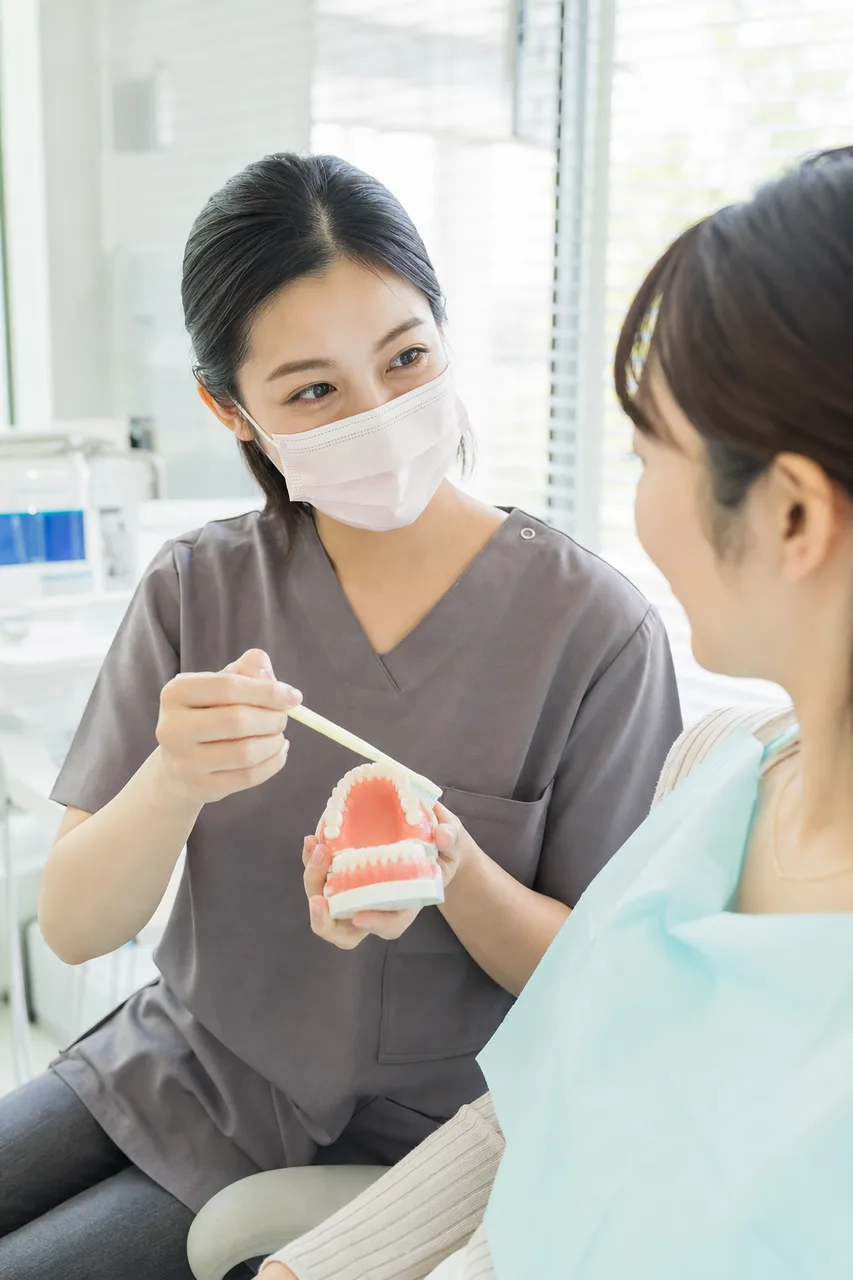 歯科医院で口腔ケアの説明を受ける患者（採用ページ用）。歯科医院で口腔ケアの説明を受ける患者をテーマに、採用ページ用として使いやすく構成した商用AI素材です。