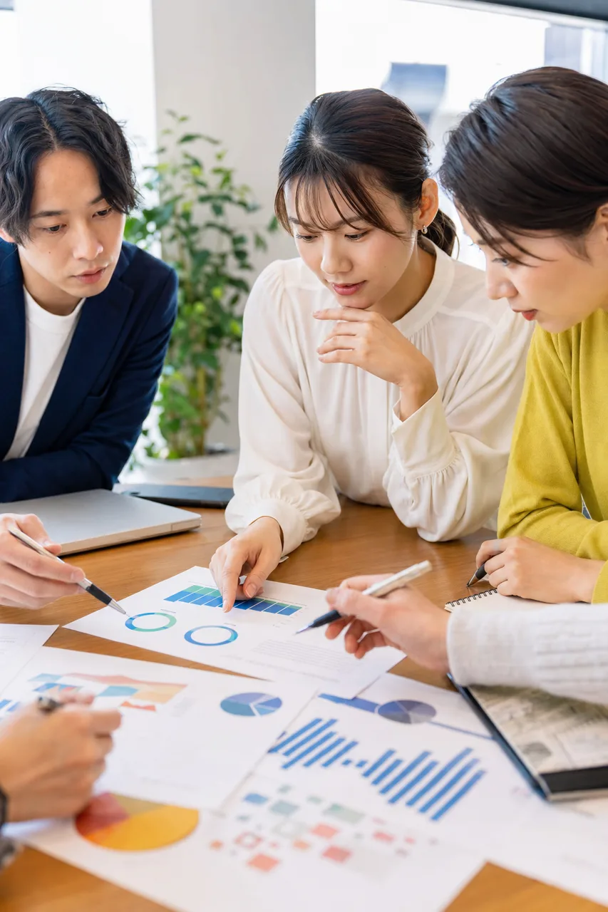 マーケティングデータを分析するチーム（パンフレット用）。マーケティングデータを分析するチームをテーマに、パンフレット用として使いやすく構成した商用AI素材です。
