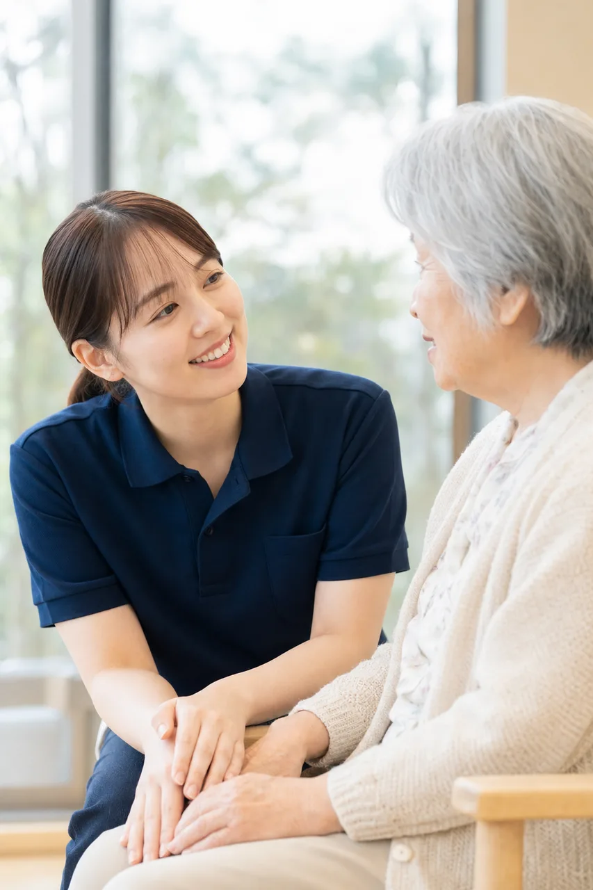 介護施設で会話する介護士と高齢者（縦型コンテンツ用）。介護施設で会話する介護士と高齢者をテーマに、縦型コンテンツ用として使いやすく構成した商用AI素材です。
