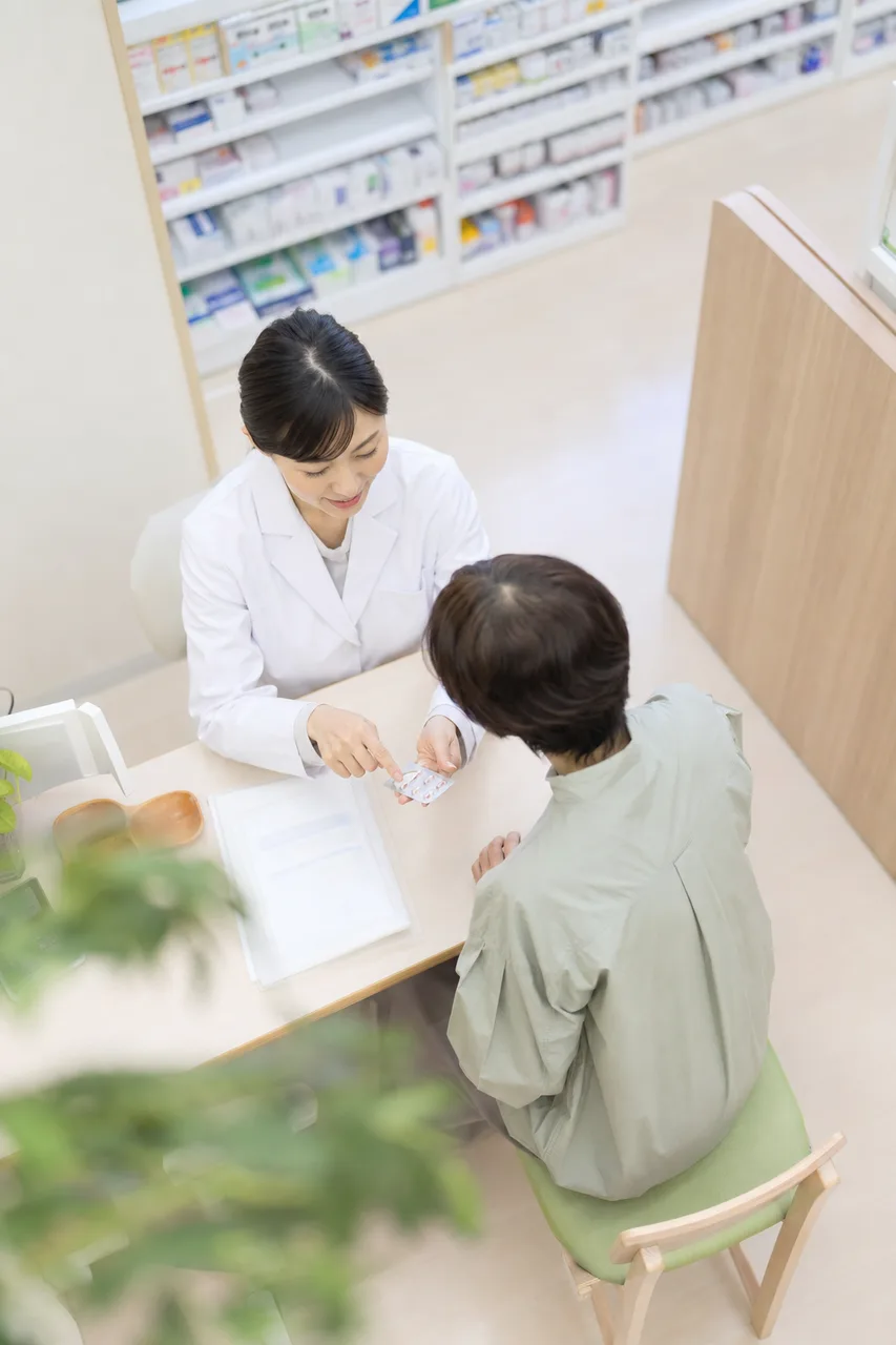 薬局で服薬説明をする薬剤師（縦型コンテンツ用）。薬局で服薬説明をする薬剤師をテーマに、縦型コンテンツ用として使いやすく構成した商用AI素材です。