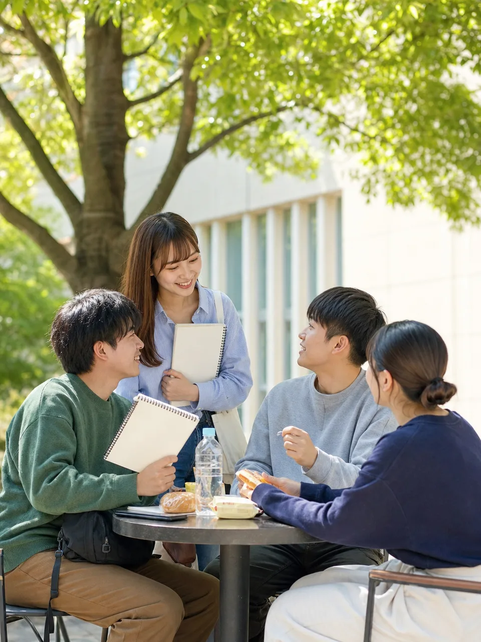 キャンパスで過ごす日本人大学生の友人（自然な縦位置写真）。大学生の友人、キャンパス、友情、学生生活の記事向け素材です。