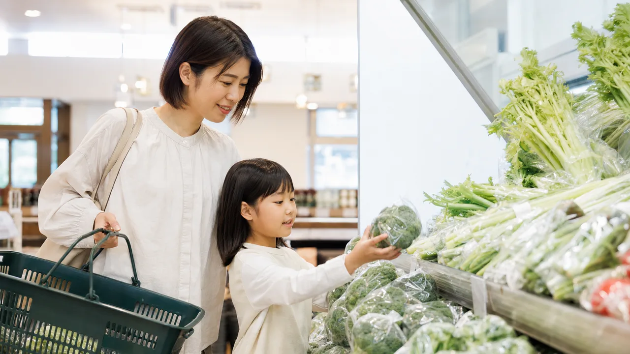 スーパーで食材を選ぶ日本人家族（横長・コピースペース）。スーパー、買い物、家計、食生活の記事に使える日常素材です。