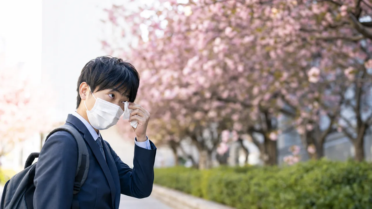 花粉症対策をする日本人通勤者（横長・コピースペース）。春の健康情報、花粉対策、医療、日用品の記事に使える生活場面です。