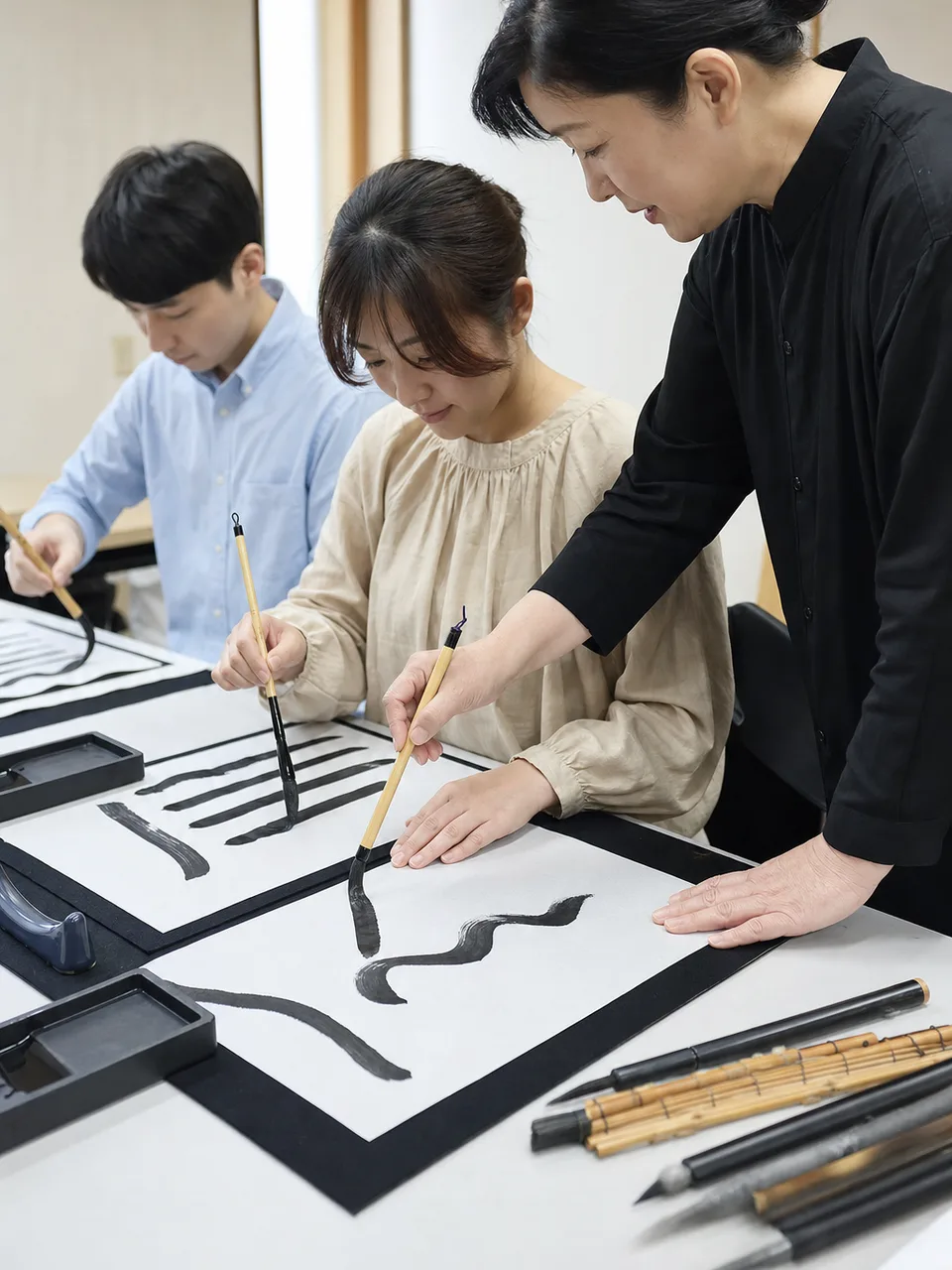 書道教室で筆を学ぶ日本人（自然な縦位置写真）。書道教室、習字、日本文化、習い事の記事向け素材です。