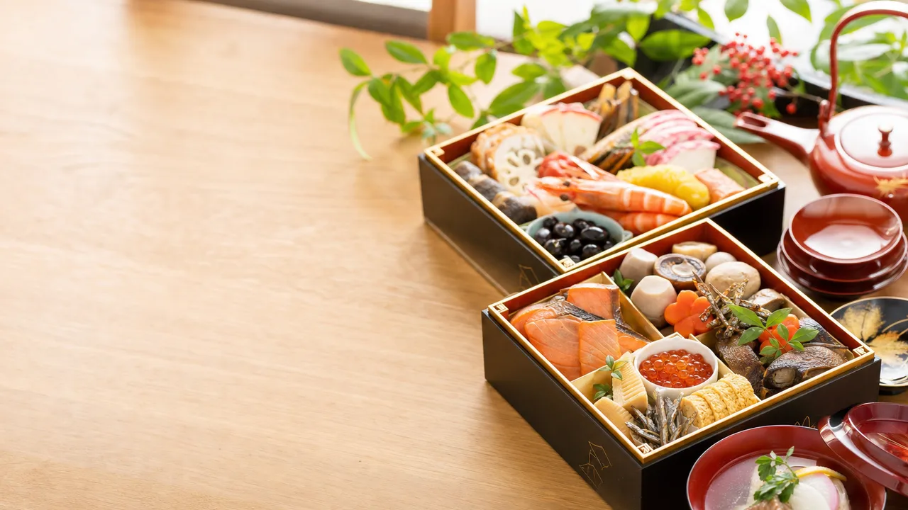 おせち料理の新年の食卓（横長・コピースペース）。年末年始の案内、食品、和食の記事に使える、華やかで自然なおせち料理素材です。