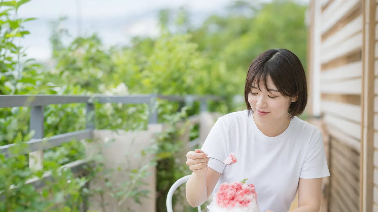 かき氷を楽しむ日本人（横長・コピースペース）。かき氷、夏、カフェ、涼をテーマにした記事向け素材です。