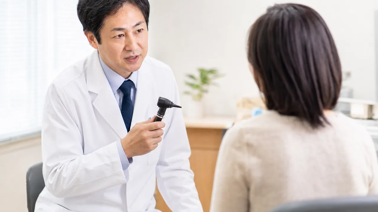 耳鼻科で診察を受ける日本人患者（横長・コピースペース）。耳鼻科、耳の診察、医療、クリニックの記事向け素材です。