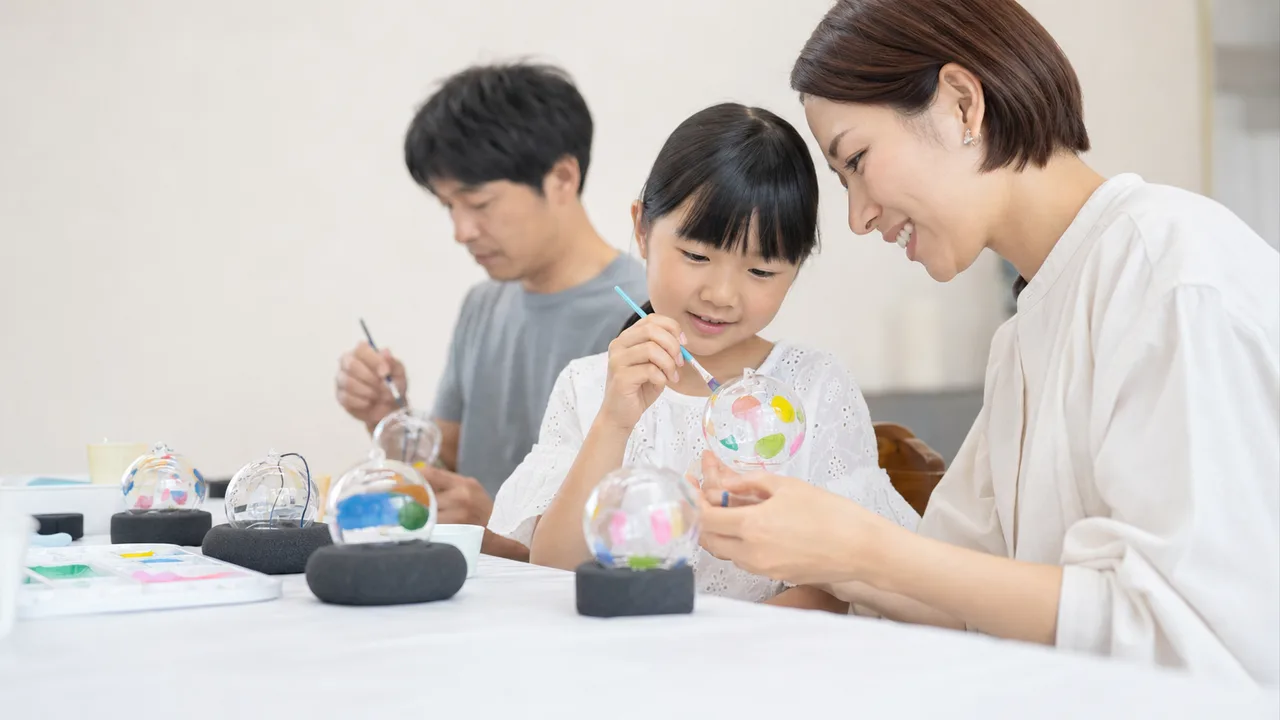 風鈴の絵付けを楽しむ日本人（横長・コピースペース）。風鈴絵付け、風鈴作り、夏の工作、伝統工芸体験の記事や案内に使える商用素材です。